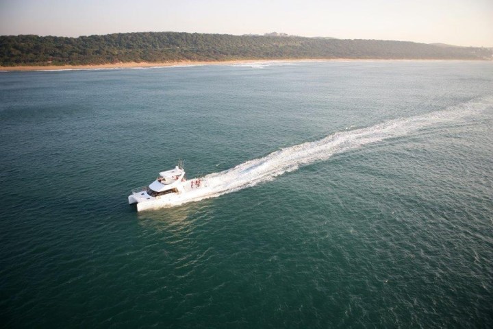 Boat sailing on the ocean with distant coastline visible.